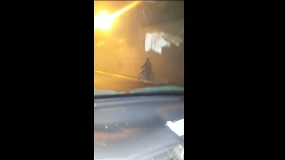 Joven conduce su bicimito por la Vía Expresa de noche