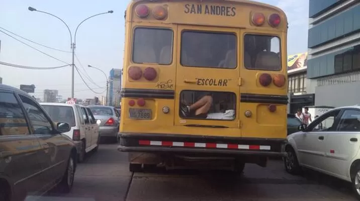 Niño viaja peligrosamente en la parte posterior de un bus escolar Niño viaja peligrosamente en la parte posterior de un bus escolar