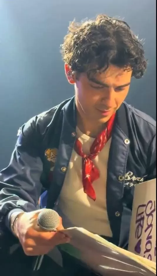 Joe Jonas observando el álbum de recortes y fotografía que una fanática peruana llevó al concierto/Foto: Instagram