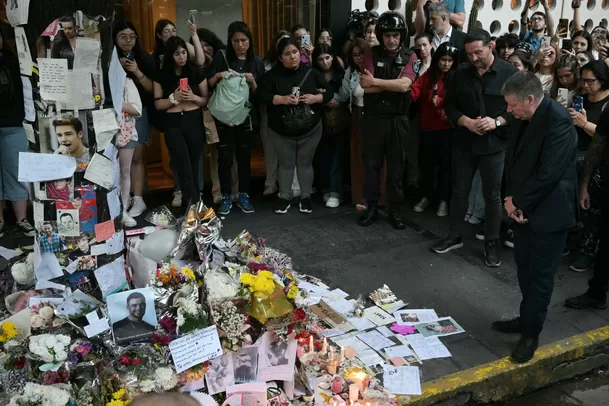 Geoff Payne viendo las flores y fotos que dejaron las fanáticas de su hijo Liam Payne en Argentina / AFP