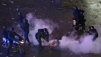 Hinchas argentinos se enfrentan a la policía después de las celebraciones por la actuación del equipo nacional en la Copa Mundial de la FIFA. (Foto: AFP)