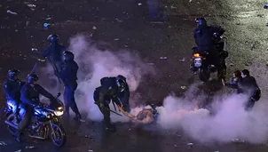 Hinchas argentinos se enfrentan a la policía después de las celebraciones por la actuación del equipo nacional en la Copa Mundial de la FIFA. (Foto: AFP)