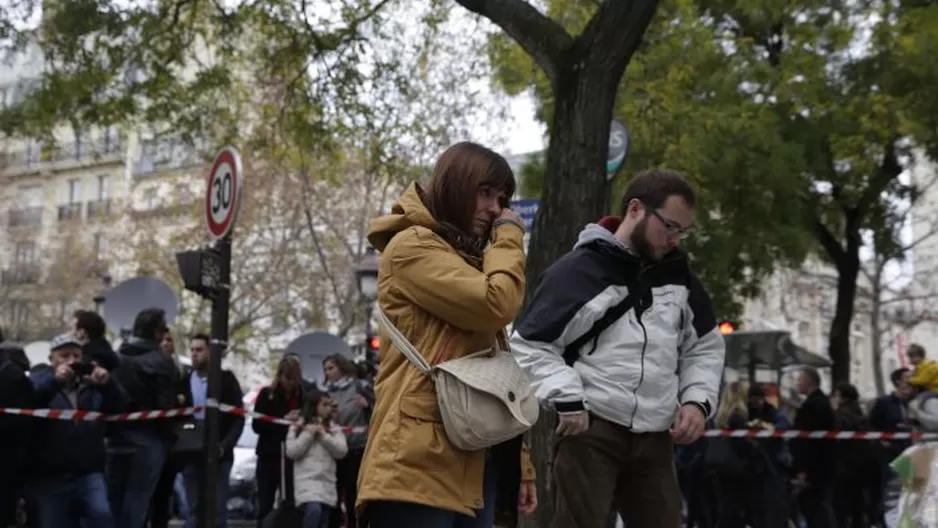  Una mujer mira los mensajes y flores que han dejado cerca al teatro El Bataclan en París / Foto: AFP