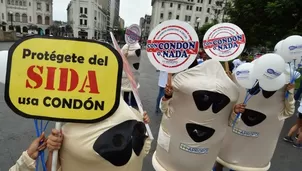 Activistas vestidos como condones sostienen letreros donde afirman "Protégente del SIDA". (Vía: AFP)