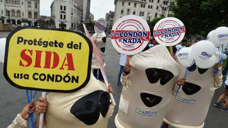 Activistas vestidos como condones sostienen letreros donde afirman "Protégente del SIDA". (Vía: AFP)