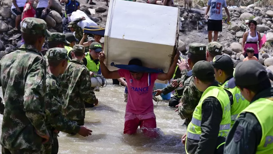 Colombianos dejando Venezuela con sus pertenencias mientras cruzan la frontera del r&iacute;o Tachira para llegar a Cucuta. (V&iacute;a: AFP)