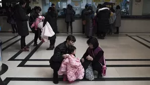 Madre y abuela cuidan de un niño en Pekín. (Vía: AFP)