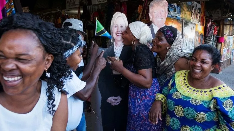 La gente posa al lado de gigantografías de Hillary Clinton y Donald Trump. (Vía: AFP)