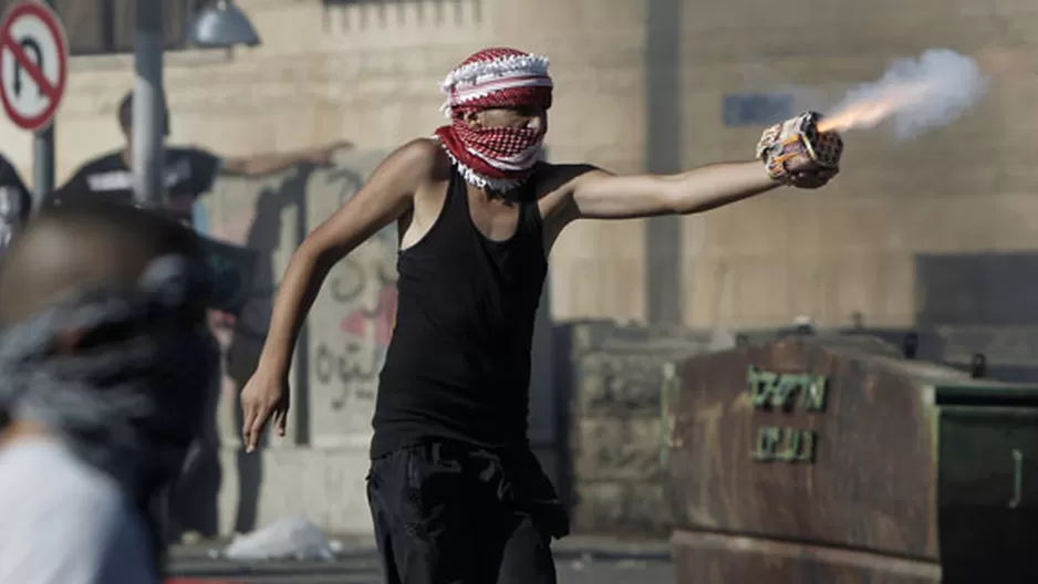 Un manifestante palestino ataca a la policía israelí durante un confrontamiento en el barrio de Shuafat después de que un adolescente fue secuestrado y asesinado en un aparente acto de venganza. (02/07/14) (Foto: AFP)