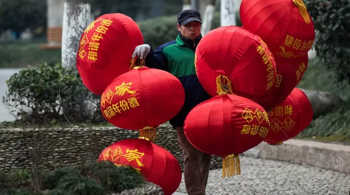 Un trabajador cargando globos de decoración. (Vía: AFP) Un trabajador cargando globos de decoración. (Vía: AFP)