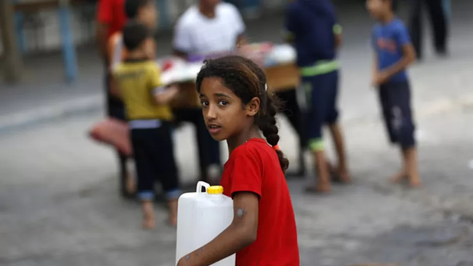 Una refugiada palestina carga agua en un bidón. (Foto: AFP)