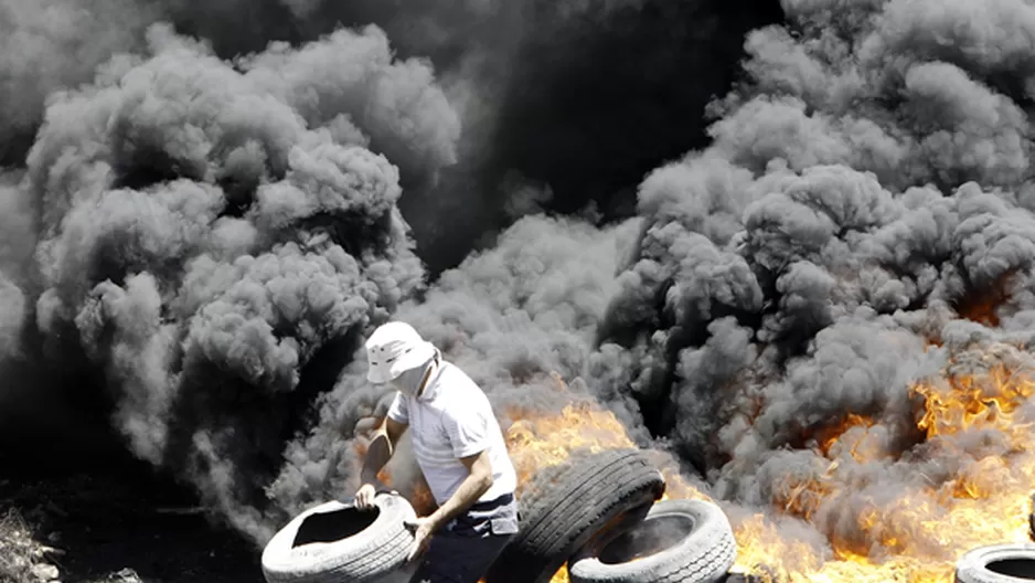 Un palestino quema llantas durante los enfrentamientos con las fuerzas de seguridad israel&iacute; despu&eacute;s de una protesta en Kfar Qaddum. (Foto: AFP)