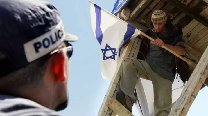 Un policía israelí le pide a un colono judío que descienda de una torre en Territorios Ocupados. (Vía: AFP) Un policía israelí le pide a un colono judío que descienda de una torre en Territorios Ocupados. (Vía: AFP)