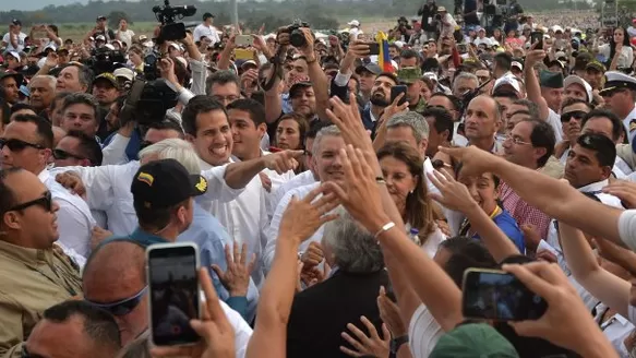 Guaidó apareció con camisa blanca, rodeado de policías y alzando el puño en alto. Foto: AFP