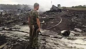 Un hombre pro-ruso permanece con su arma sobre lo que fue la nave de Malaysia Airlines. Foto: REUTERS/Maxim Zmeyev