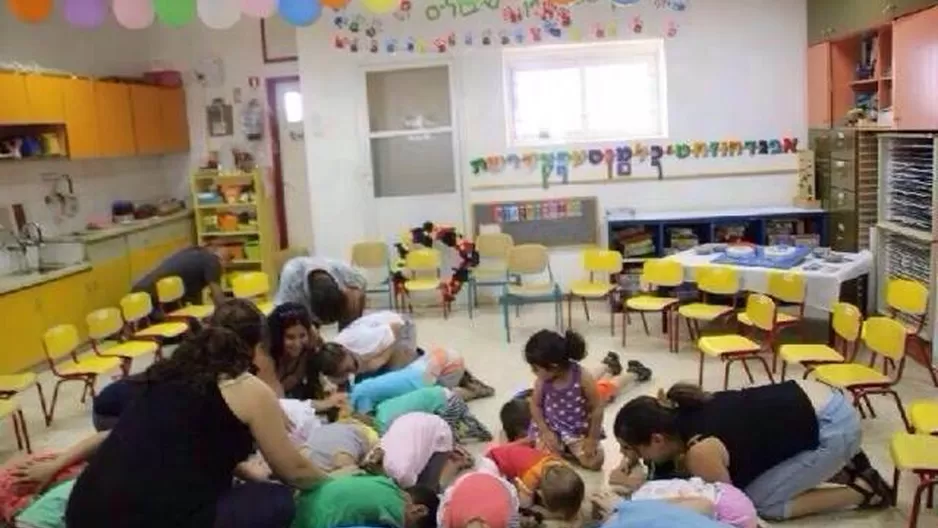 Niños se cubren las cabezas al sonar la alarma de bomba. (Foto: Ariela Bitterman) 