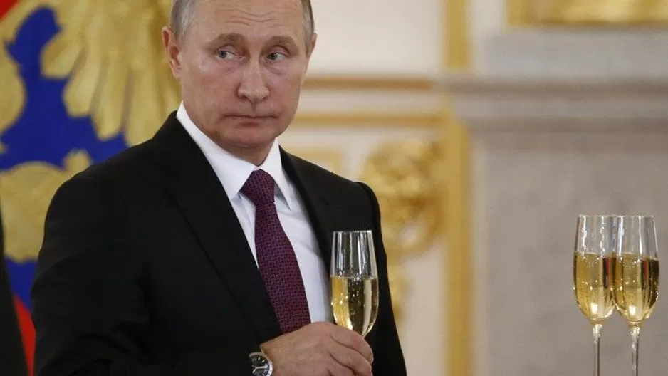 Presidente Putin sostiene una copa de champagne durante una conferencia en el Kremlin. (Vía: AFP)