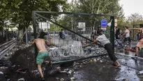 Refugiados intentan remover las vallas de metal en la frontera de Hungr&iacute;a con Serbia. (V&iacute;a: AFP)