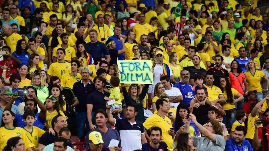 Mujer sostiene un cartel que reza 'Fuera Dilma' durante las Eliminatorias para el mundial de Rusia 2018. (Vía: AFP)