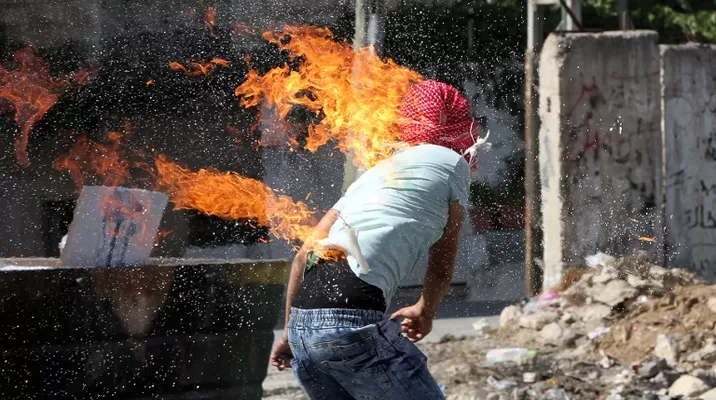 La ropa de un estudiante palestino se quema después de que se prendiera en fuego al lanzar un cóctel molotov a soldados israelíes. (Vía: AFP) La ropa de un estudiante palestino se quema después de que se prendiera en fuego al lanzar un cóctel molotov a soldados israelíes. (Vía: AFP)