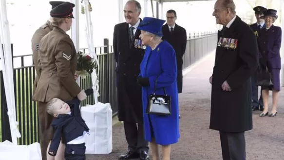 Reina Isabel junto a niño británico. (Vía: AFP)